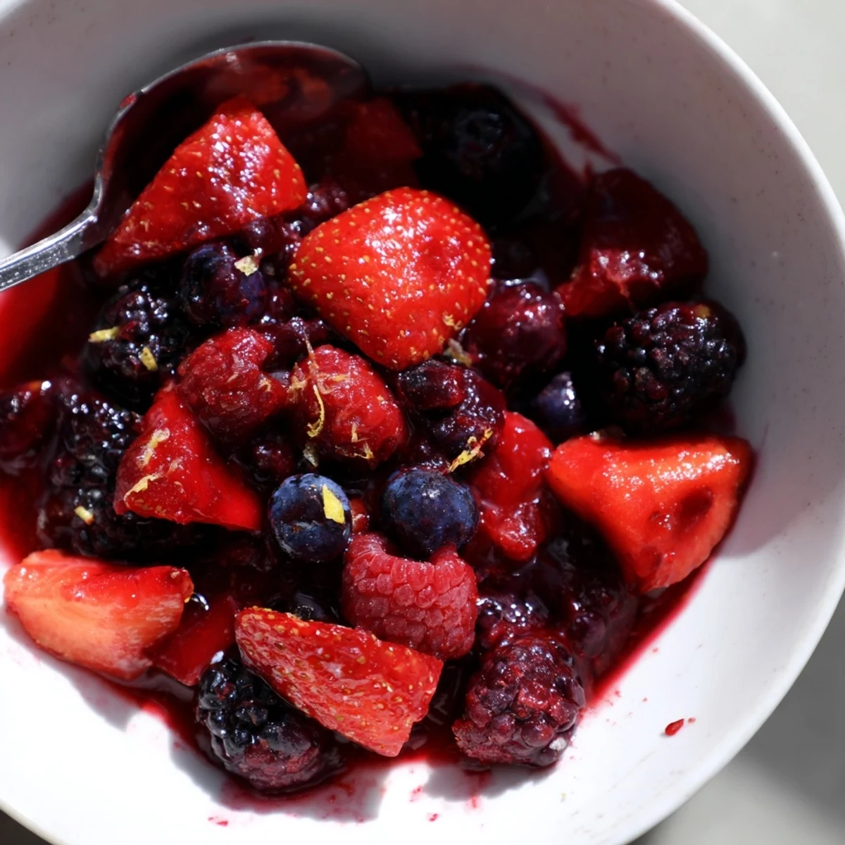 Saftige Mischung aus Erdbeeren, Himbeeren und Brombeeren in einer süßen Sauce.  